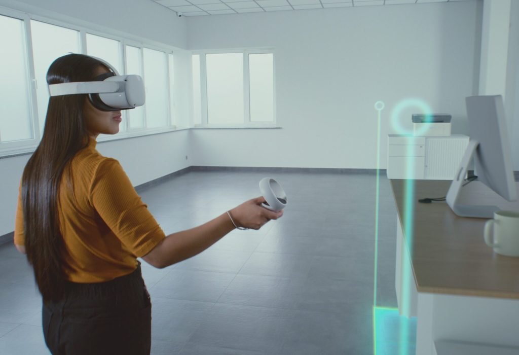Creative Asian female designer wearing augmented reality headset uses virtual interior design software and controllers to build office room with 3D furniture and equipment. Futuristic VFX animation.